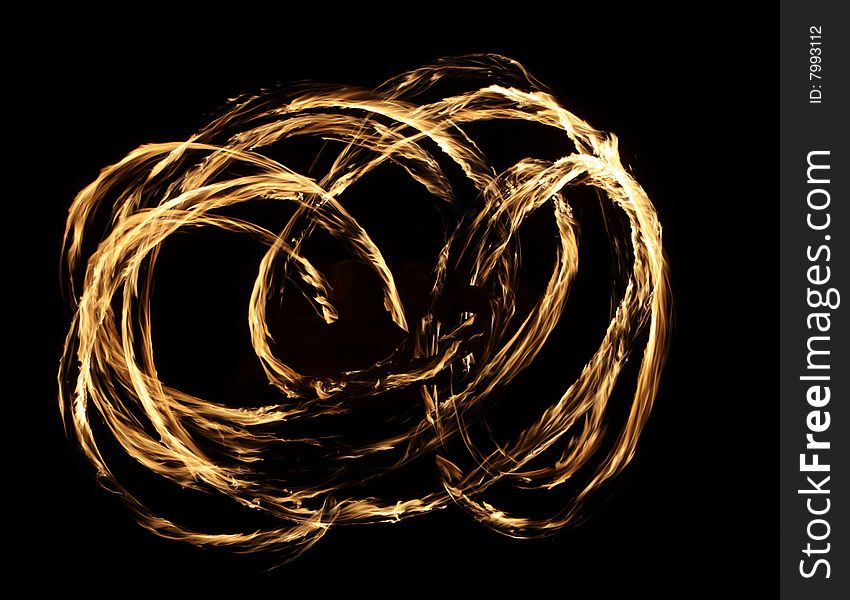 Fire dancer making circles of fire on the beach. Fire dancer making circles of fire on the beach