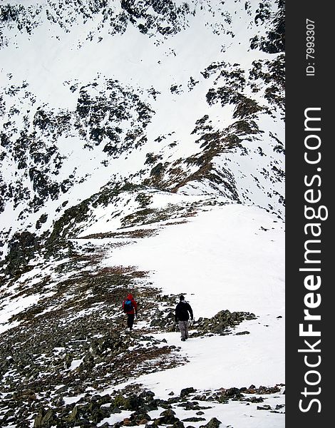 Hiking on a snow covered mountain ridge. Hiking on a snow covered mountain ridge