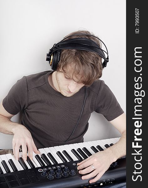 Game process on a MIDI-keyboard, man in headphones. Game process on a MIDI-keyboard, man in headphones