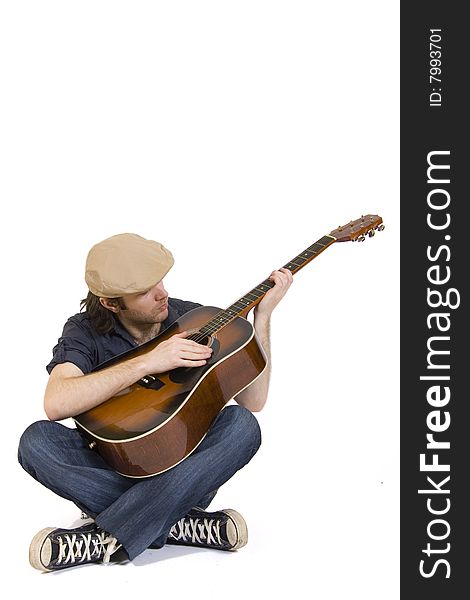 Man playing his acoustic guitar seated. Man playing his acoustic guitar seated