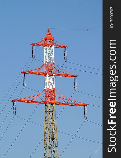 High-tension pole in front of a blue sky