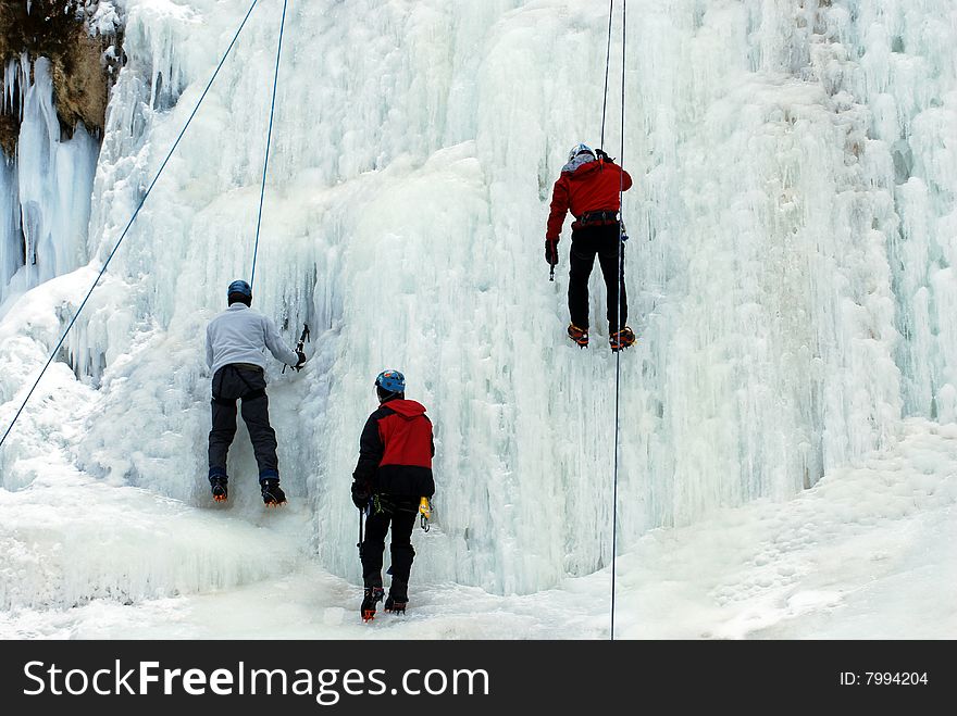 Three men climb frozen waterfall. Three men climb frozen waterfall