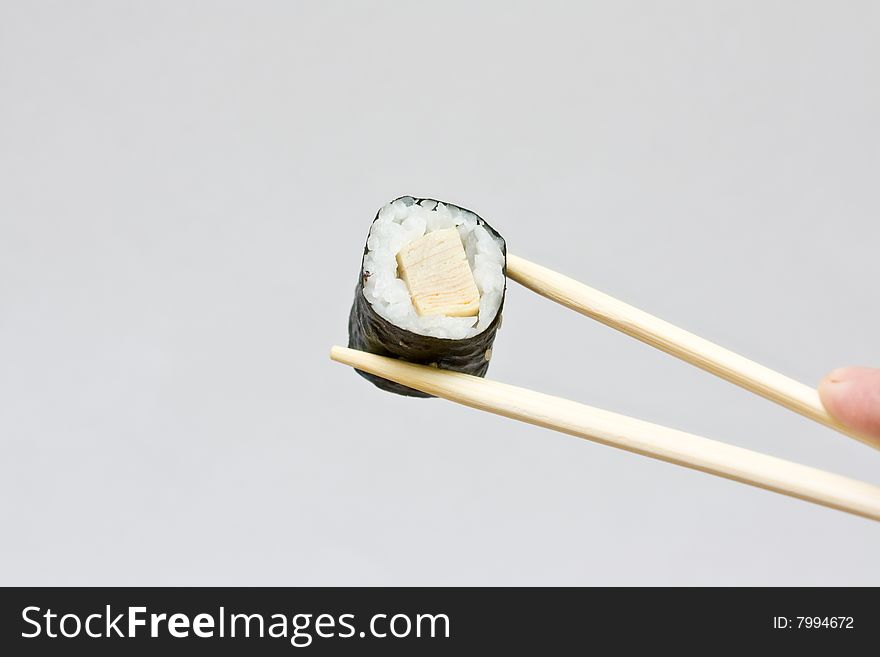 Sushi and chopsticks on the neutral background