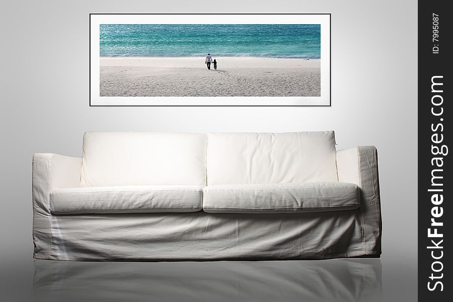 A white modern sofa with a photo of a family at the sea on the wall. A white modern sofa with a photo of a family at the sea on the wall