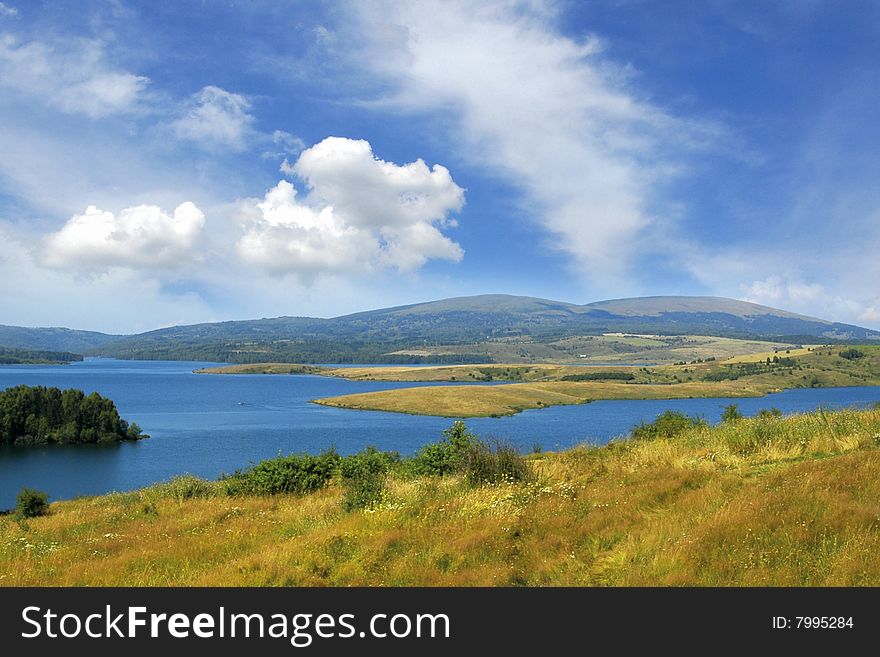 Holiday on Vlasina Lake, blue sky, clouds, grass. Holiday on Vlasina Lake, blue sky, clouds, grass
