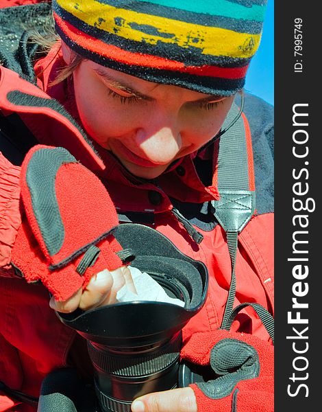 Tourist photographer cleans camera lens with white tissue. Tourist photographer cleans camera lens with white tissue