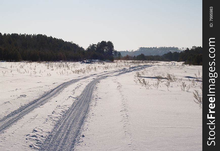 Winter road through a snow field