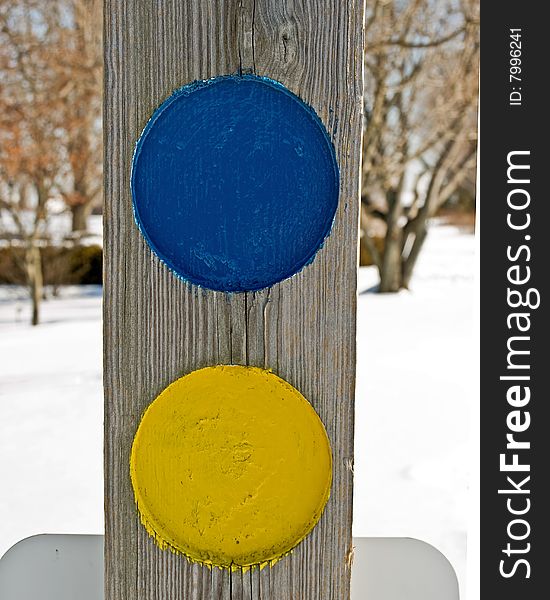 bright blue and yellow circles on a weathered post