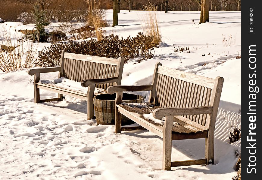 Snow covered weathered wooden benches. Snow covered weathered wooden benches