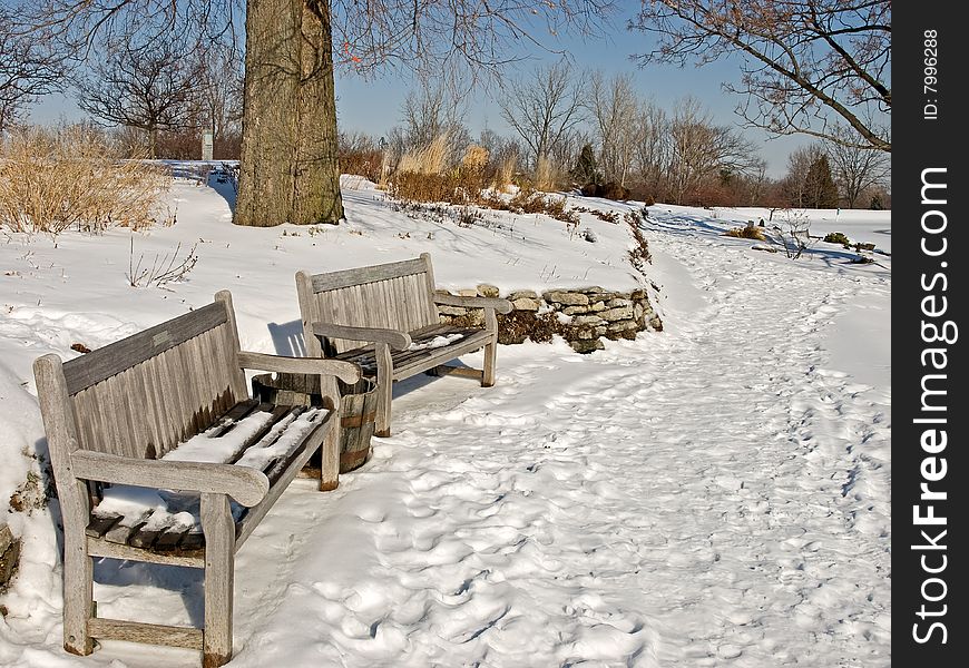 Snow covered weathered wooden benches. Snow covered weathered wooden benches