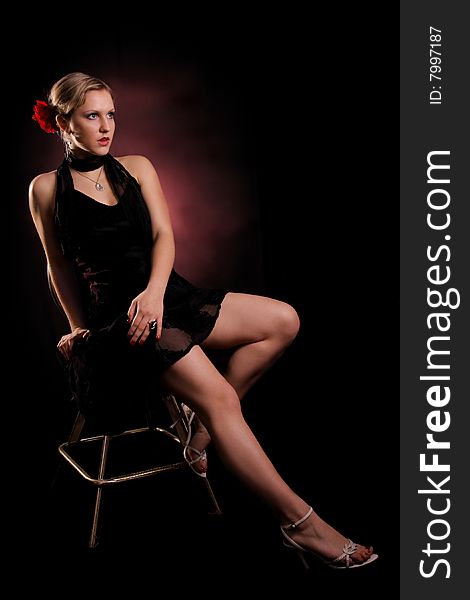 Young lady in black dress sitting on a chair. Young lady in black dress sitting on a chair