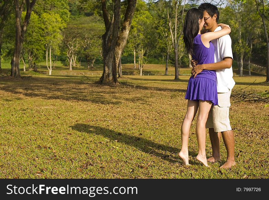 A loving couple enjoying intimate moments in the outdoor. A loving couple enjoying intimate moments in the outdoor