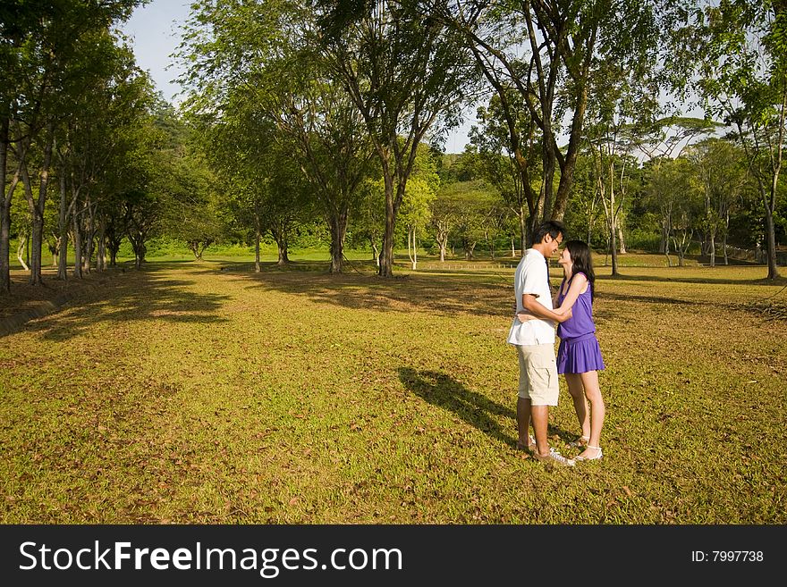 A loving couple enjoying intimate moments in the outdoor. A loving couple enjoying intimate moments in the outdoor