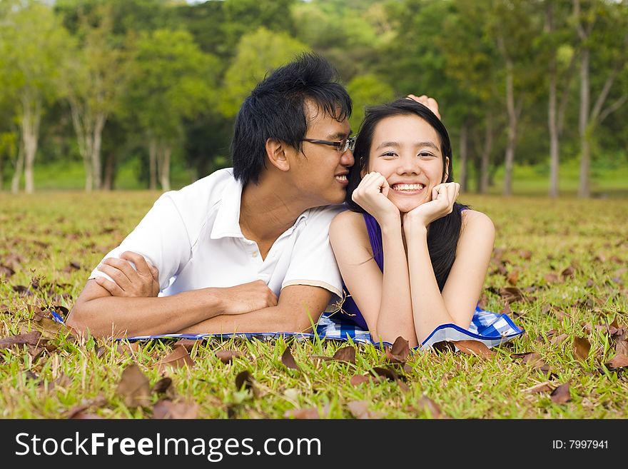 A loving couple enjoying intimate moments in the outdoor. A loving couple enjoying intimate moments in the outdoor