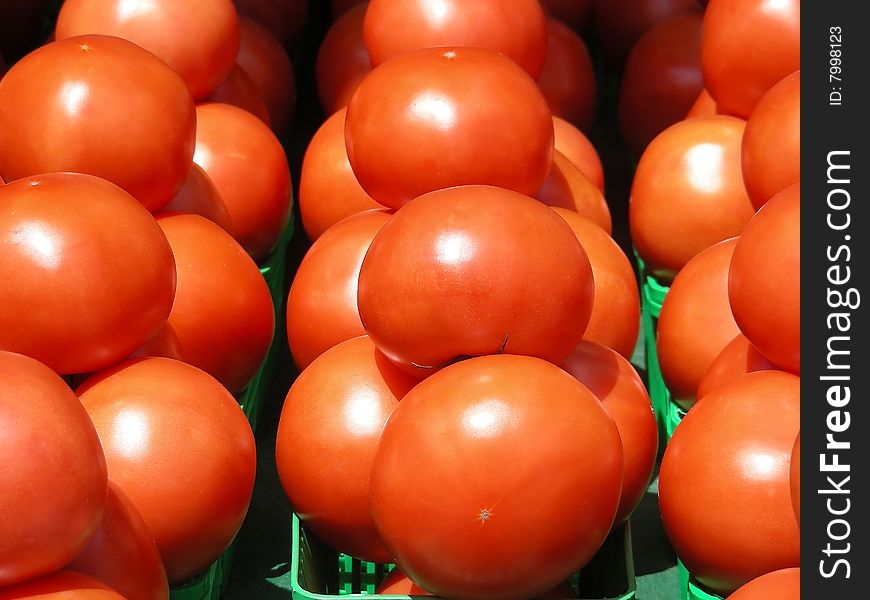 A display of ripe red yummy looking tomatoes at the local farmer's market. A display of ripe red yummy looking tomatoes at the local farmer's market.