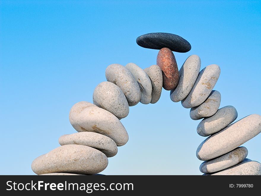 White sea pebble combined in an arch with a black stone with top. White sea pebble combined in an arch with a black stone with top