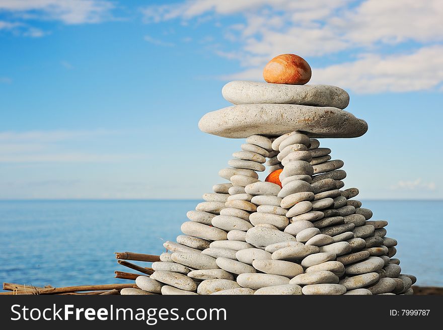 Pyramid from a sea pebble with the big stones with top. Pyramid from a sea pebble with the big stones with top