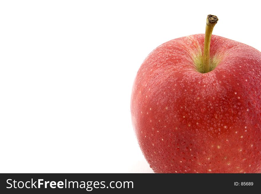 A red apple covered in water droplets. A red apple covered in water droplets