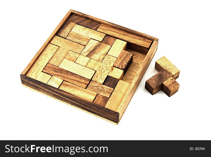 A wooden puzzle needs one more piece to finish it. A wooden puzzle needs one more piece to finish it