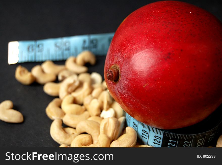 This is an image of mango, measuring tape and cashew nuts. (Please let me know where the image will be used by leaving a message in the Comments Section/See Portfolio). This is an image of mango, measuring tape and cashew nuts. (Please let me know where the image will be used by leaving a message in the Comments Section/See Portfolio)