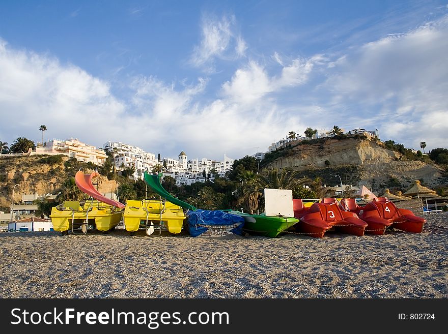Colourful pedal powered boats on a Spanish beach. Colourful pedal powered boats on a Spanish beach