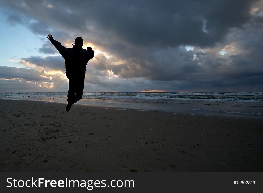 Person jumps in the air on a beautiful night on the beach. Person jumps in the air on a beautiful night on the beach
