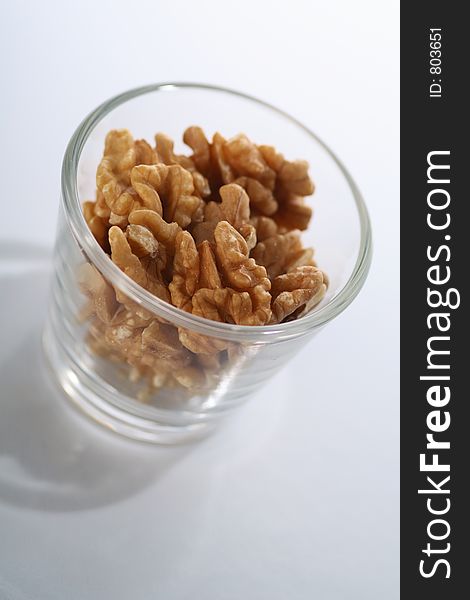 A glass full of crackes walnuts. A glass full of crackes walnuts