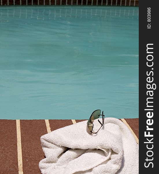 Glasses and towel beside a pool. Glasses and towel beside a pool