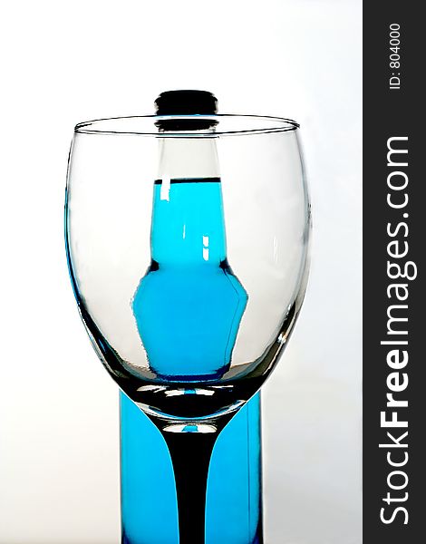 Distorted blue soda bottle seen through a glass. Distorted blue soda bottle seen through a glass.