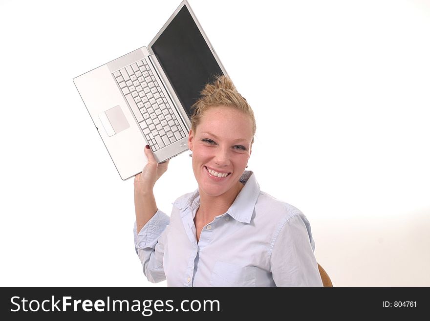 Smiling but possibly frustrated young woman seriously considering throwing her laptop computer. Smiling but possibly frustrated young woman seriously considering throwing her laptop computer