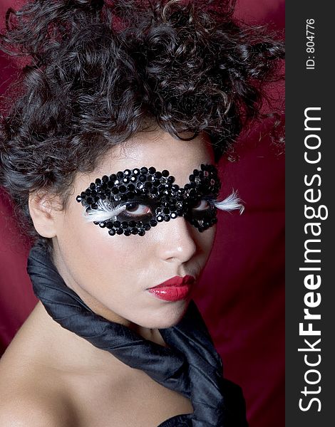 Attractive young Hispanic woman wearing a black gem mask. Attractive young Hispanic woman wearing a black gem mask
