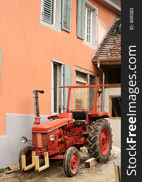 Red tractor in a street in alsace