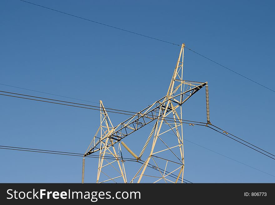 High voltage lines are held aloft by a giant power tower. High voltage lines are held aloft by a giant power tower.