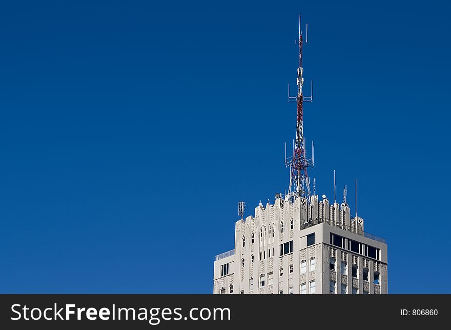 The top of a tall apartment building with a radio broadcast antenna. The top of a tall apartment building with a radio broadcast antenna.