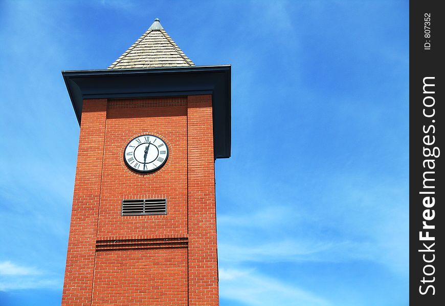 Red brick clock tower with blue sky background