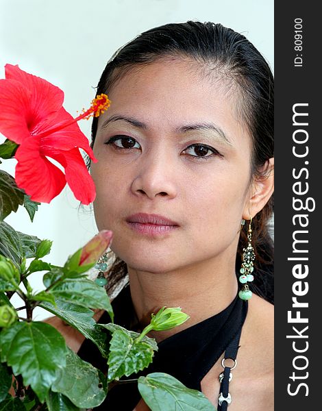 A beautiful asian girl and a red flower. A beautiful asian girl and a red flower