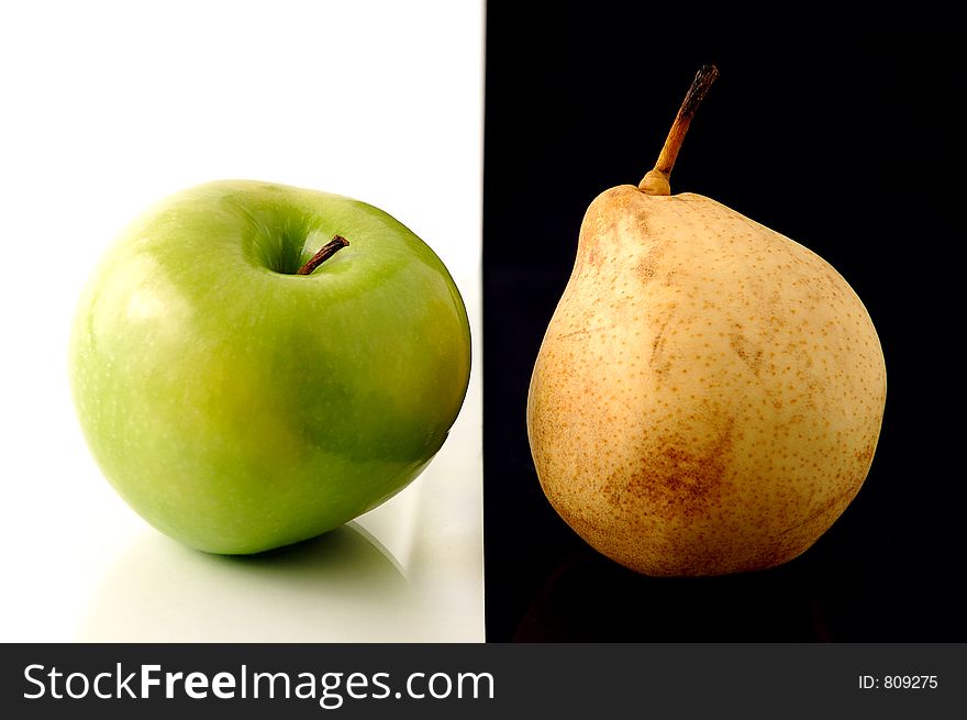 Granny Smith apple and yellow pear on artistic background