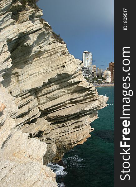 Tourist resort of Benidorm in the background with hotels and appartments large sedimentary rock in the foreground