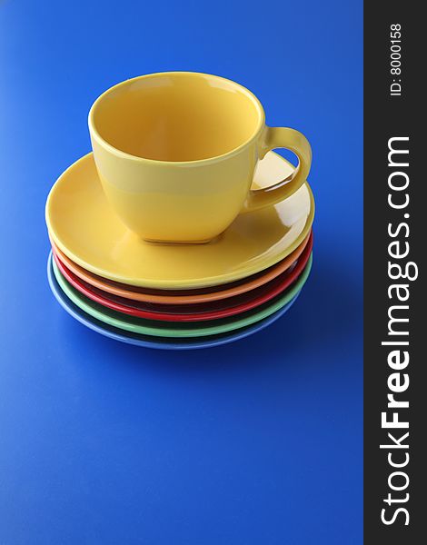Yellow cup, five plates on blue background.