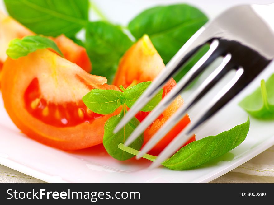 Fresh tomatoes with basil on a plate. Fresh tomatoes with basil on a plate