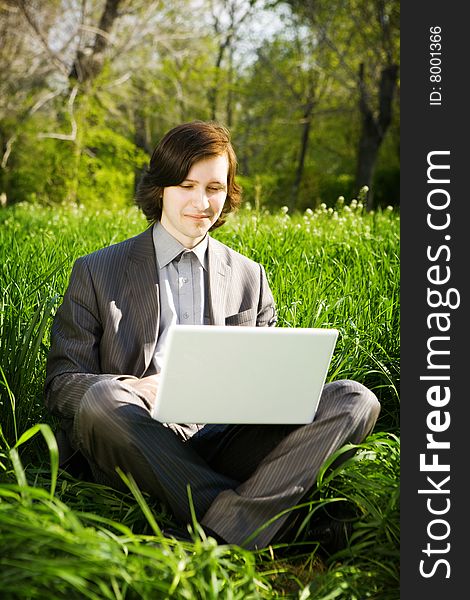 Man with laptop on the grass. Man with laptop on the grass