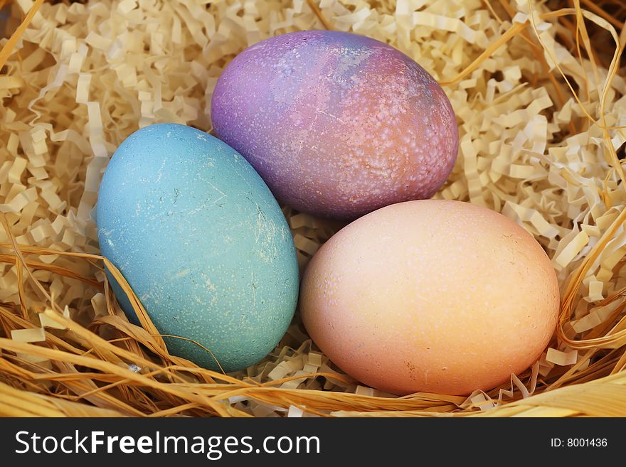 Three colorful easter eggs in wicker basket