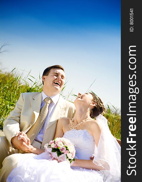 Laughing bride and groom outdoors. Laughing bride and groom outdoors