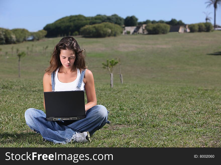 Young woman with laptop at the park