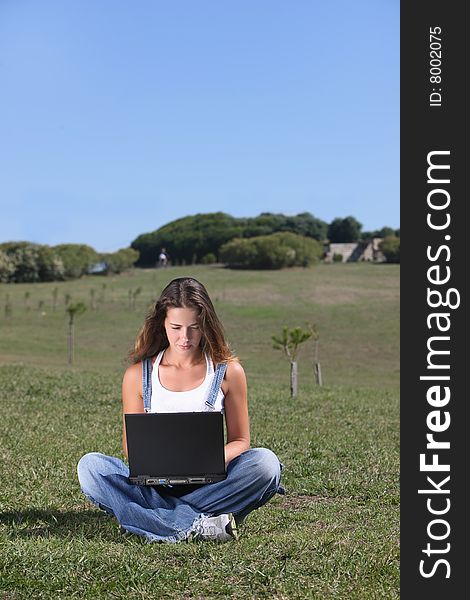 Young woman with laptop at the park