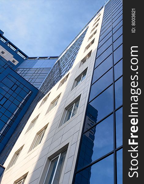 Glass facade of a modern urban building with glass windows. Glass facade of a modern urban building with glass windows