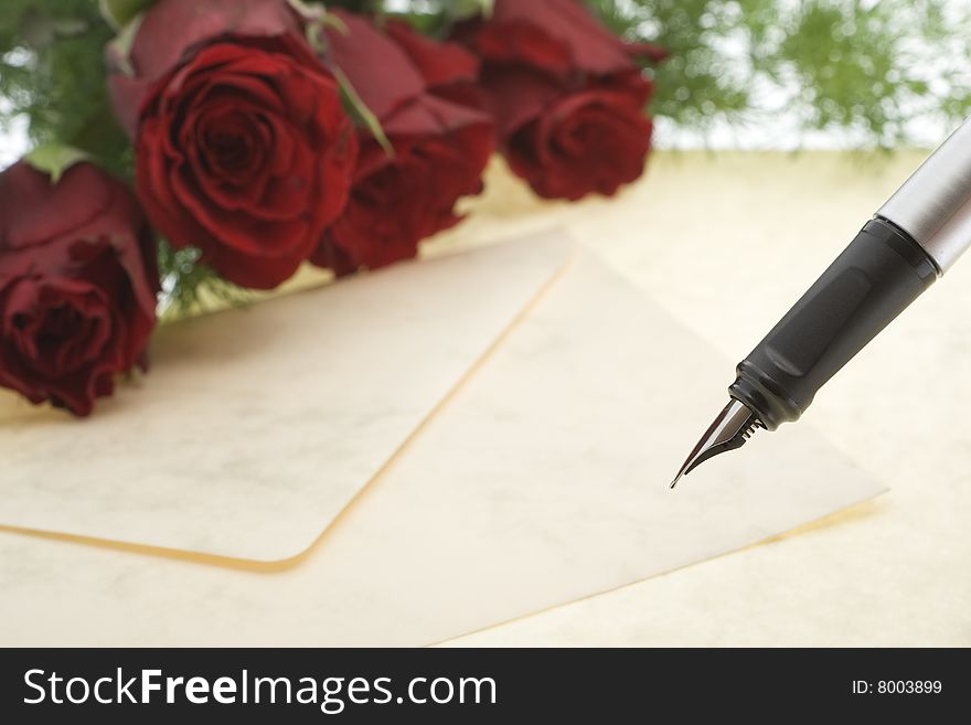 Red roses with envelope and pen