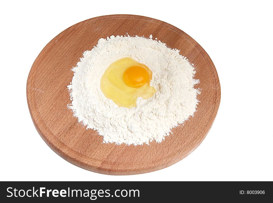 Flour and  eggs on wooden board isolated on a white background. Flour and  eggs on wooden board isolated on a white background.