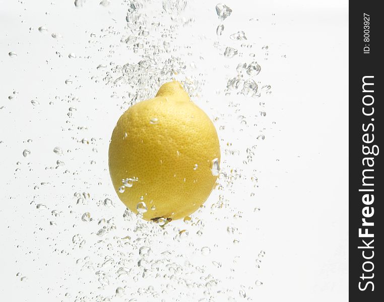 Alone lemon is dropped into clean and fresh water. Alone lemon is dropped into clean and fresh water.