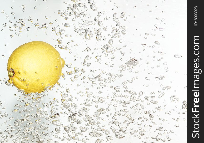 Splash bubbles after dropped lemon into clean water. Splash bubbles after dropped lemon into clean water.